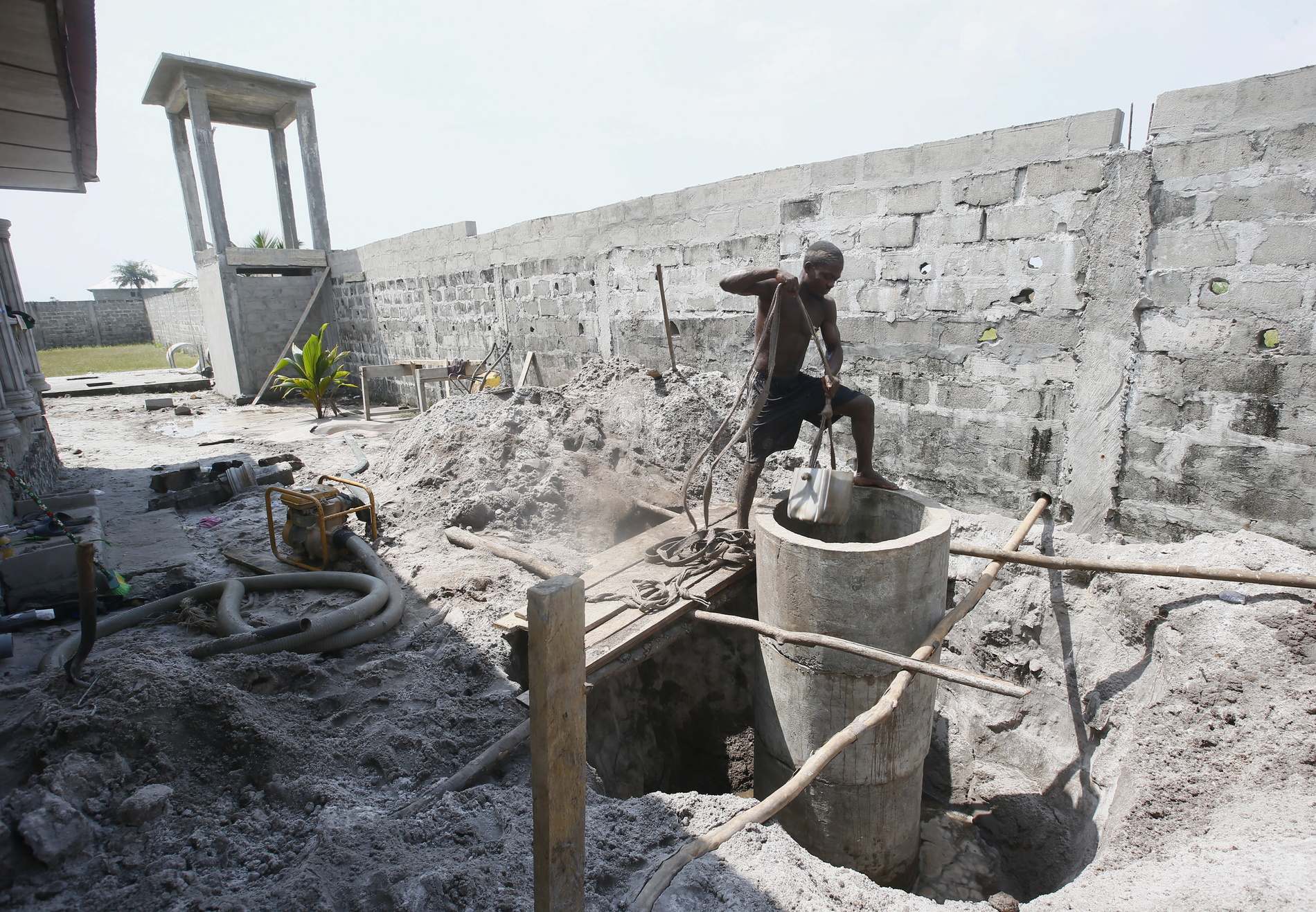A man digging at a well construction site.