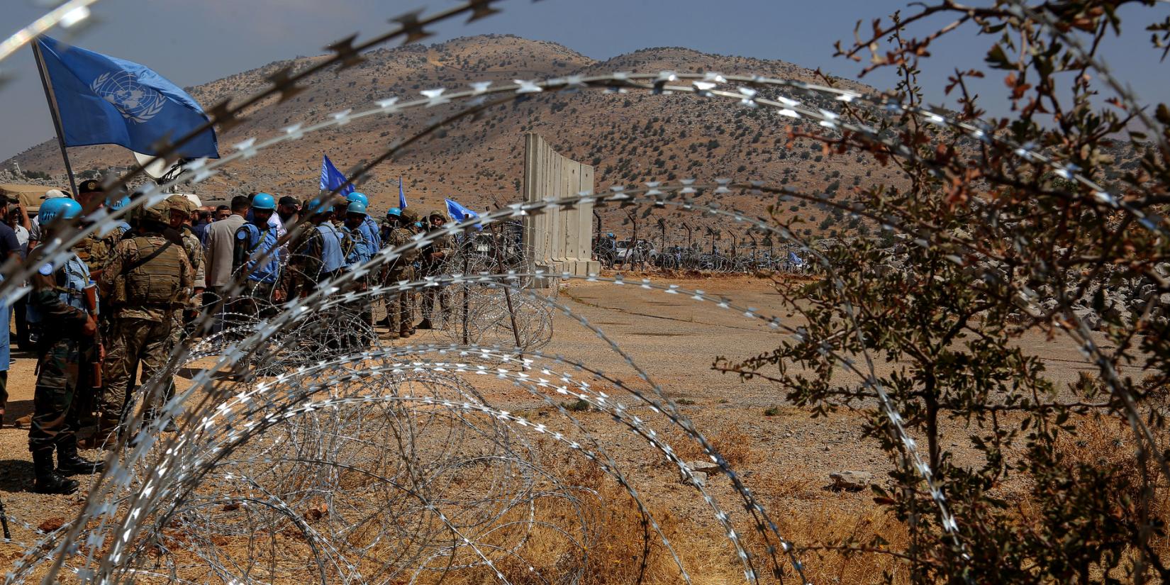 UN blue helmets are seen from a barbed wire representing the so-called Blue Line between Lebanon and Israel