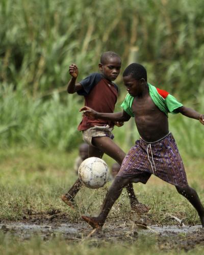 Congolese children play football in the middle of the conflict zone in front of UN peacekeepers' quarters. © Keystone