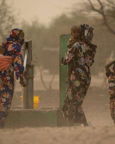 African women pump water from a well in Chad. 